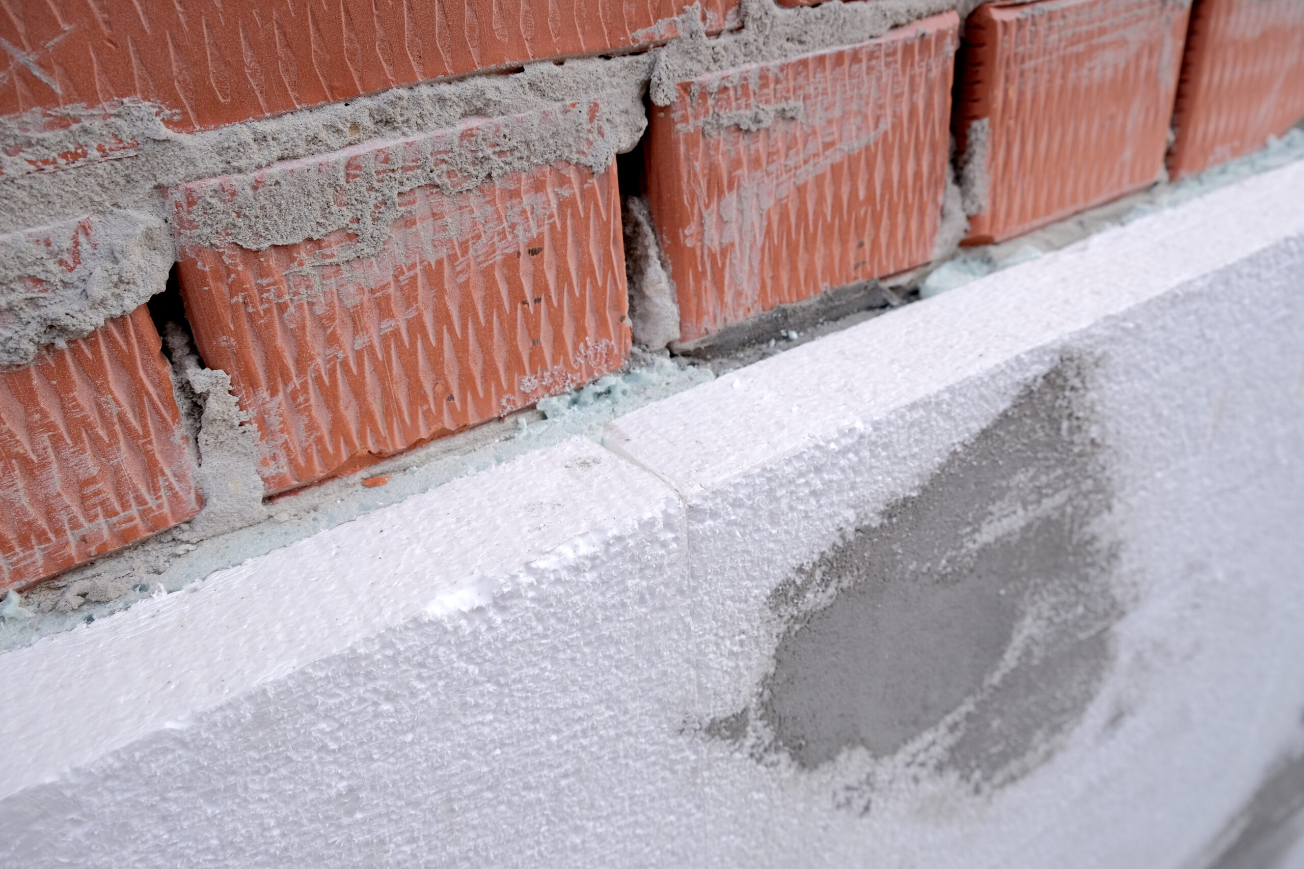 close up detail of brick house wall with rigid styrofoam insulat