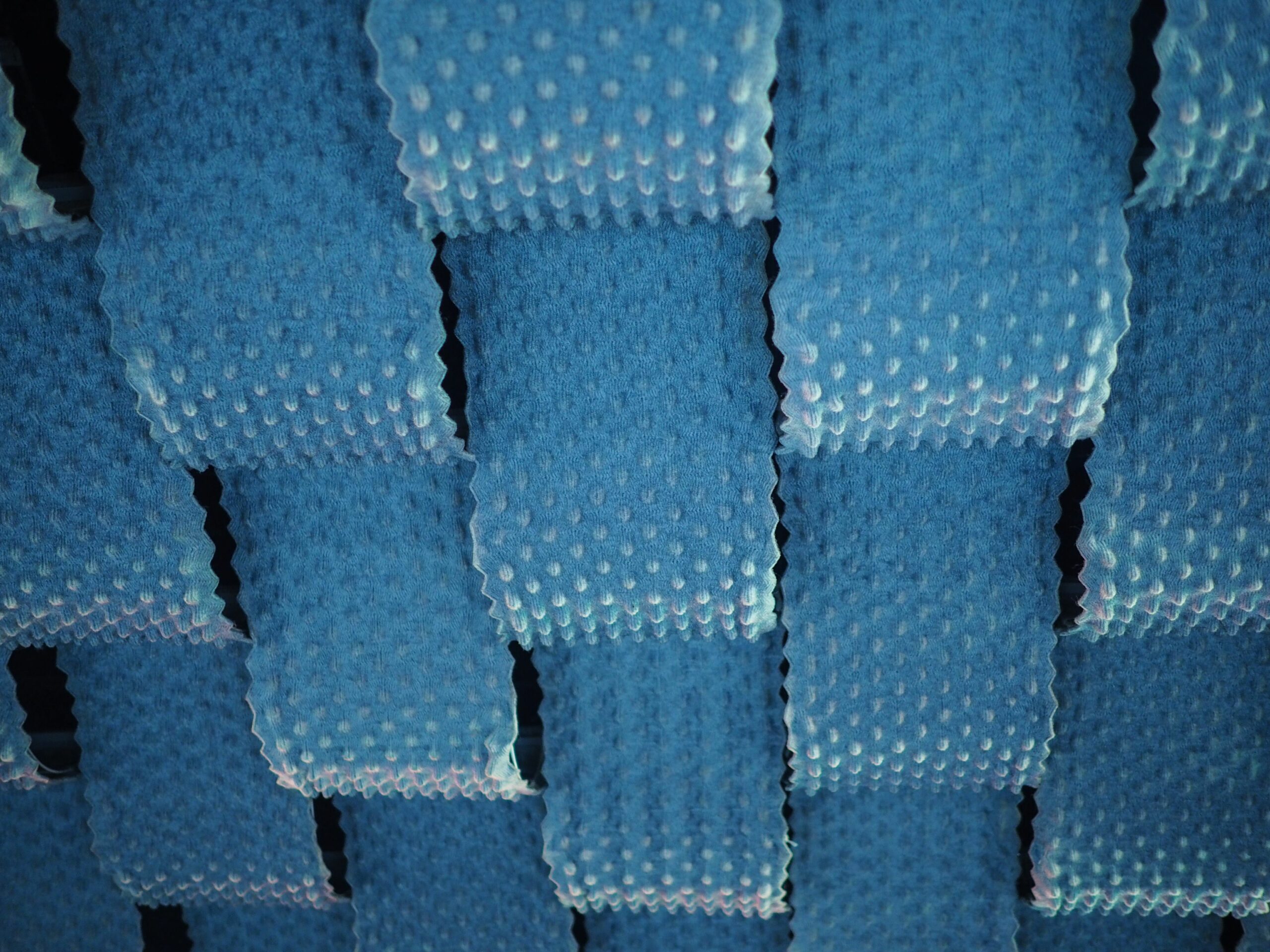 low angle closeup shot of a ceiling covered in blue sound dampening fabric