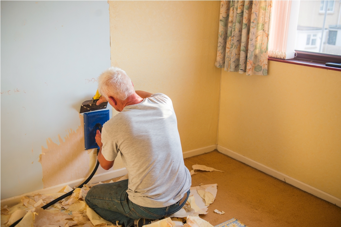a man removes old wallpaper from a wall using spec 2022 11 15 17 03 12 utc