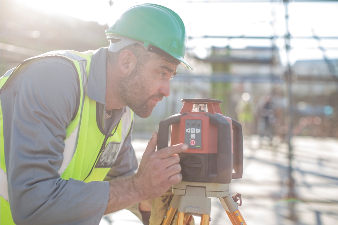 construction worker using surveying equipment