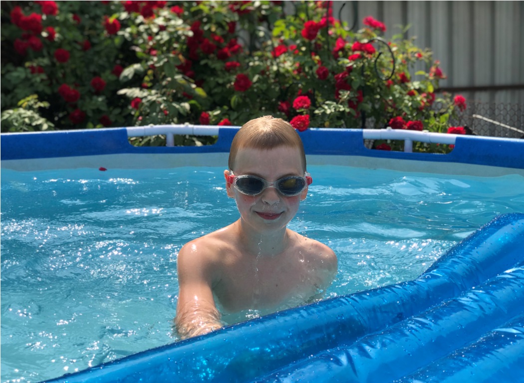 the boy swims in the pool in the country summer a 2022 11 15 16 08 27 utc