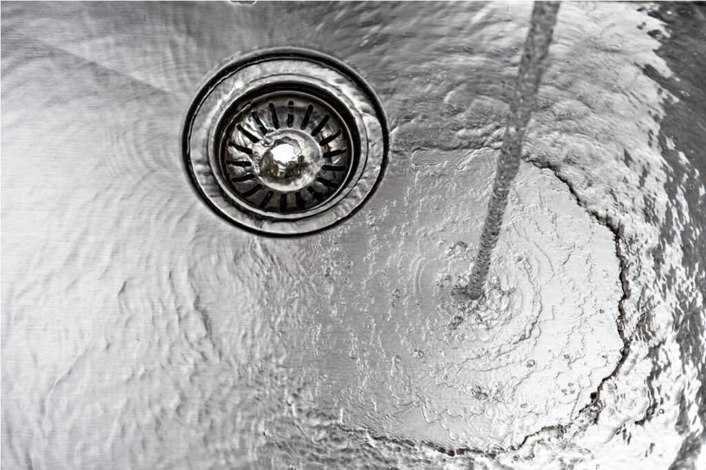 water drains down a stainless steel sink