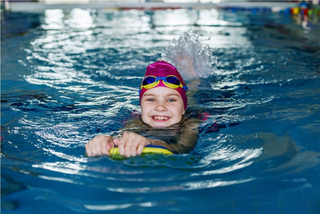 child schoolgirl learns to swim with board in pool 2022 06 15 00 12 22 utc