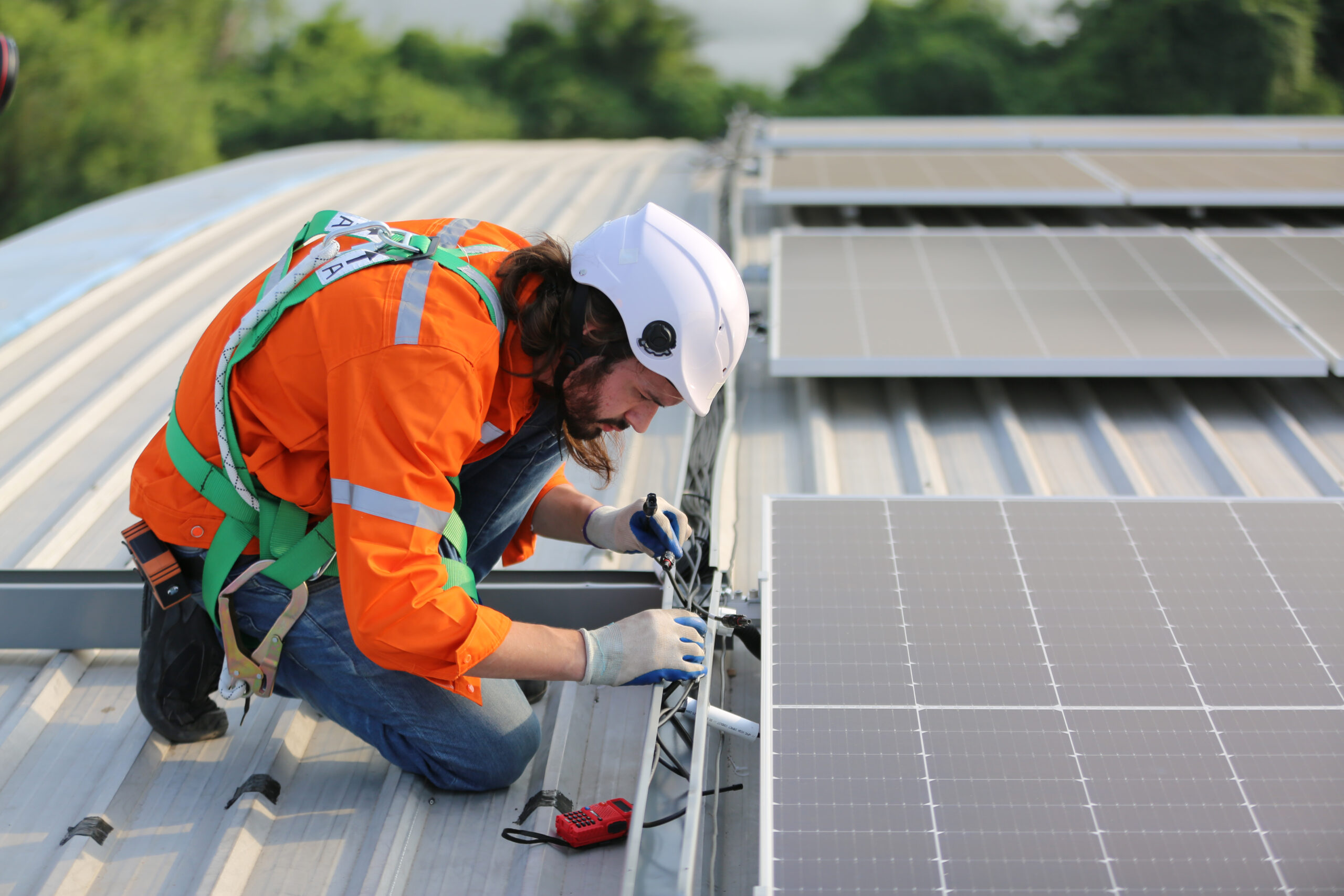 professional worker installing solar panels on the roof of a house.