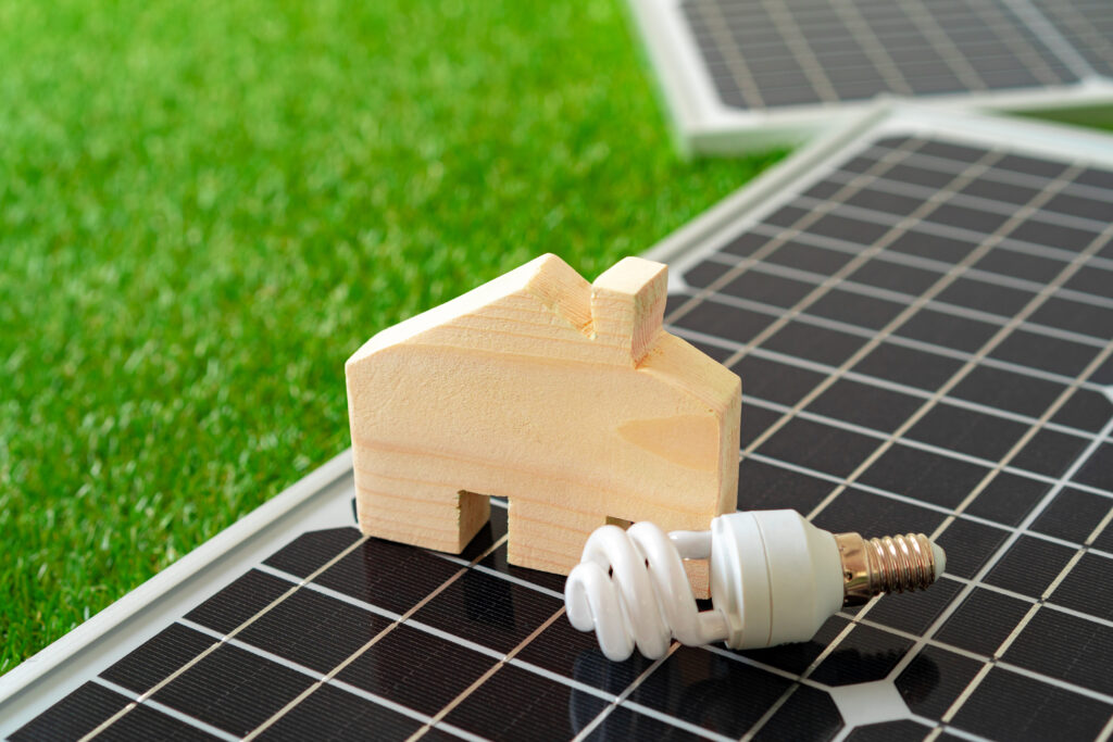 wooden house miniature and solar panel close up