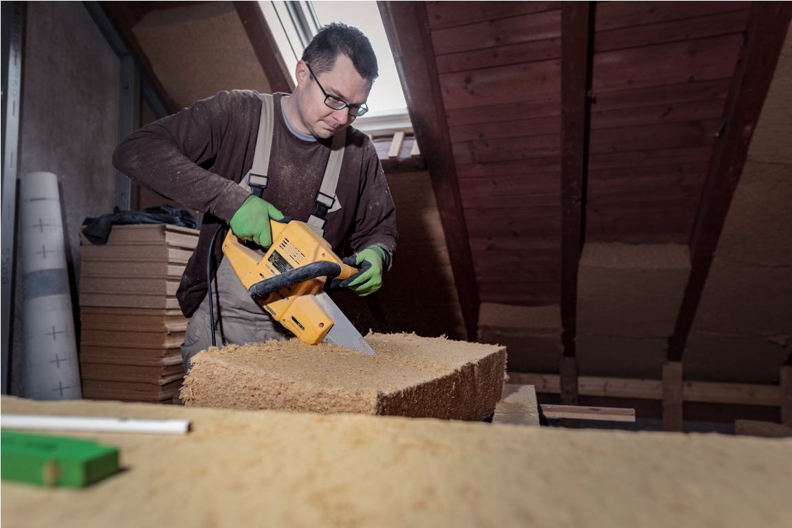roof insulation, worker placing wood fibre insulation at the roof