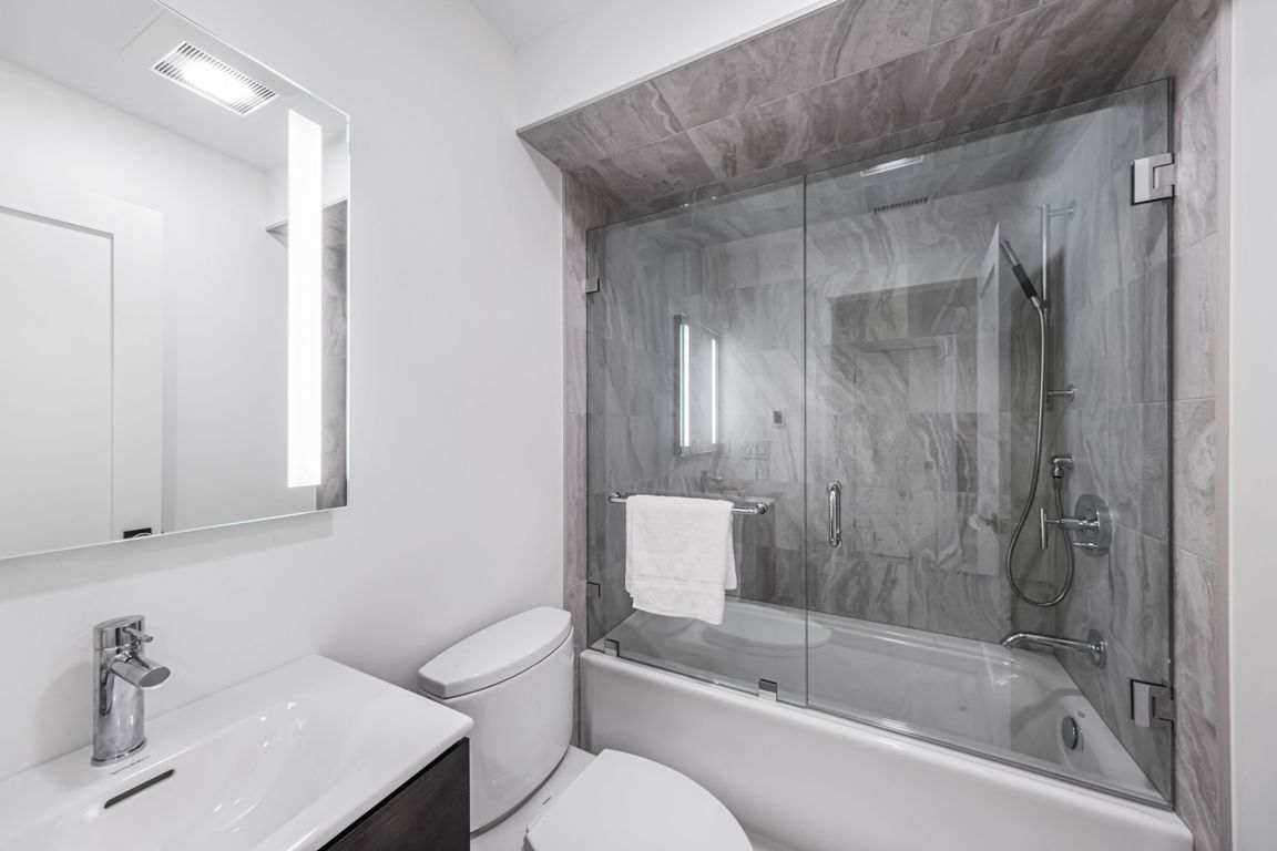 a stylish bathroom with a glass partitioned bathtub